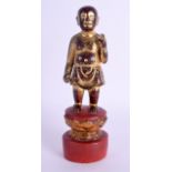 AN 18TH/19TH CENTURY CHINESE RED AND GOLD LACQUER STANDING BUDDHA modelled upon a lotus column. 23