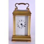 AN EARLY 20TH CENTURY MINIATURE FRENCH BRASS CARRIAGE CLOCK with white enamel dial. 10 cm high inc
