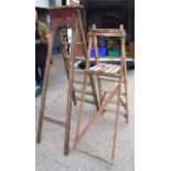 A VINTAGE WOODEN STEP LADDER, together with a similar smaller example. 160 cm high.