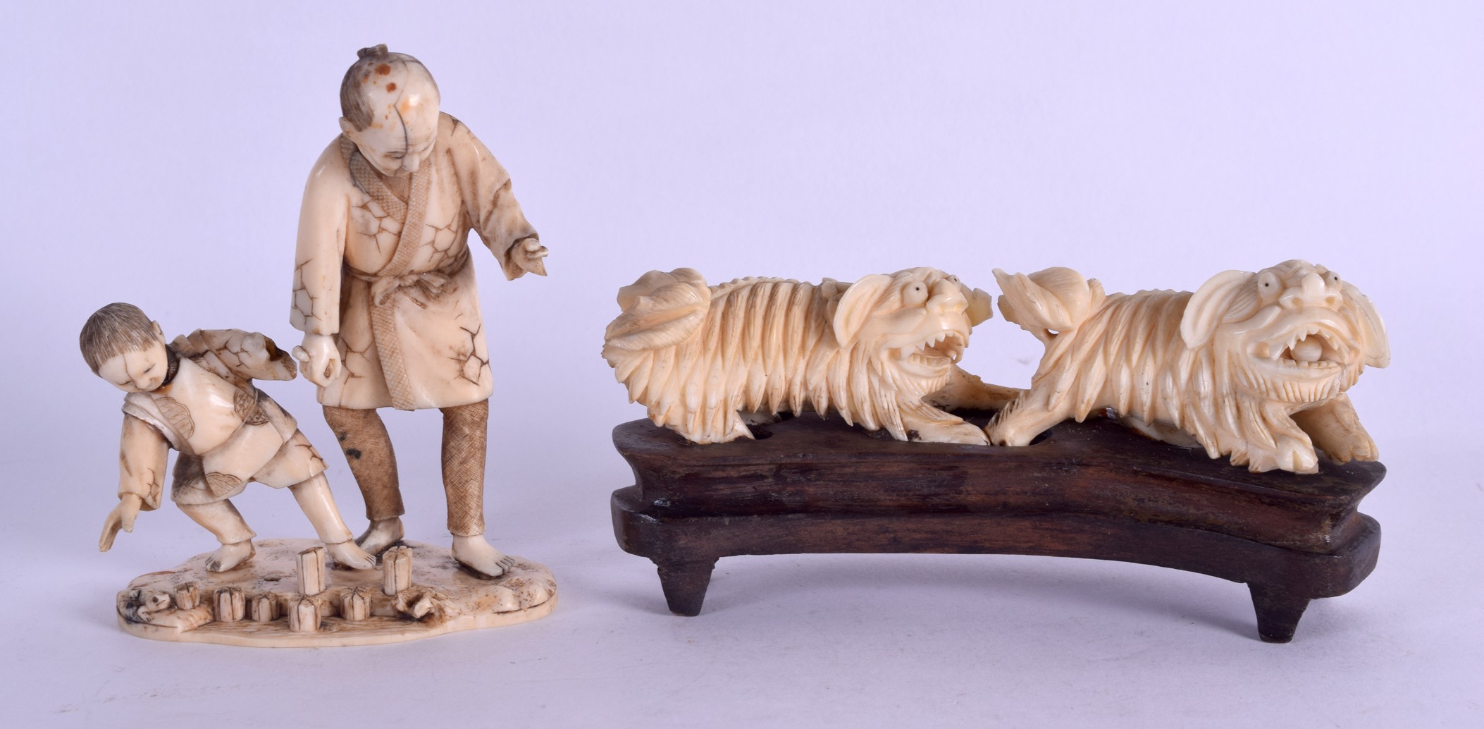 A 19TH CENTURY CHINESE CARVED IVORY DOUBLE BUDDHIST LION GROUP together with a Meiji period ivory