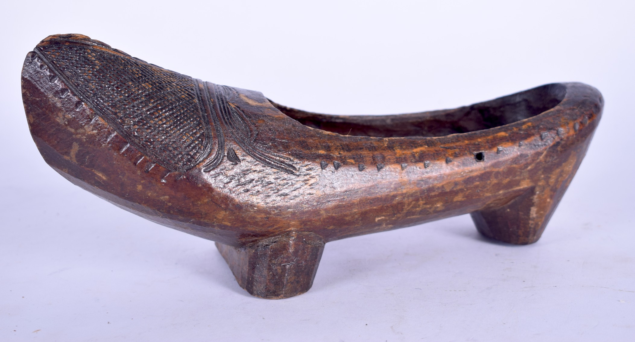 AN UNSUAL CARVED TRIBAL WOODEN SHOE, with thatch work type decoration to front. 33 cm long.