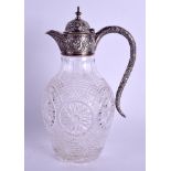 A 19TH CENTURY CONTINENTAL SILVER AND CRYSTAL CLARET JUG decorated with foliage and relief. 24 cm