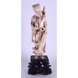 A 19TH CENTURY CHINESE CARVED IVORY FIGURE OF AN IMMORTAL modelled in engraved robes upon a fitted