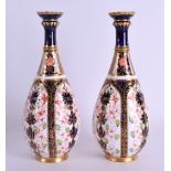 A PAIR OF ROYAL CROWN DERBY BOTTLE VASES painted with an imari pattern. 18 cm high.