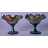 A PAIR OF 20TH CENTURY IRIDESCENT GLASS VASES, formed with petal shaped rim and decorated internally