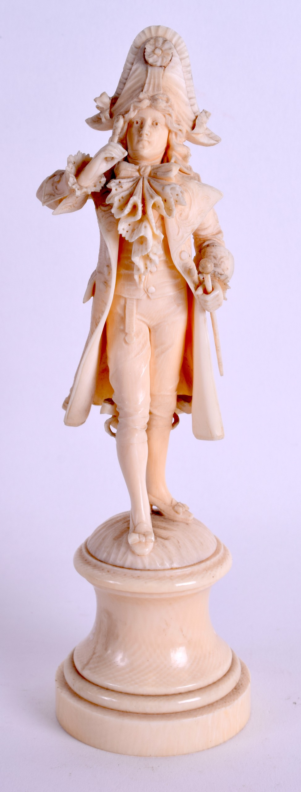 A MID 19TH CENTURY EUROPEAN CARVED IVORY FIGURE OF A DANDY modelled upon a circular base. 20 cm