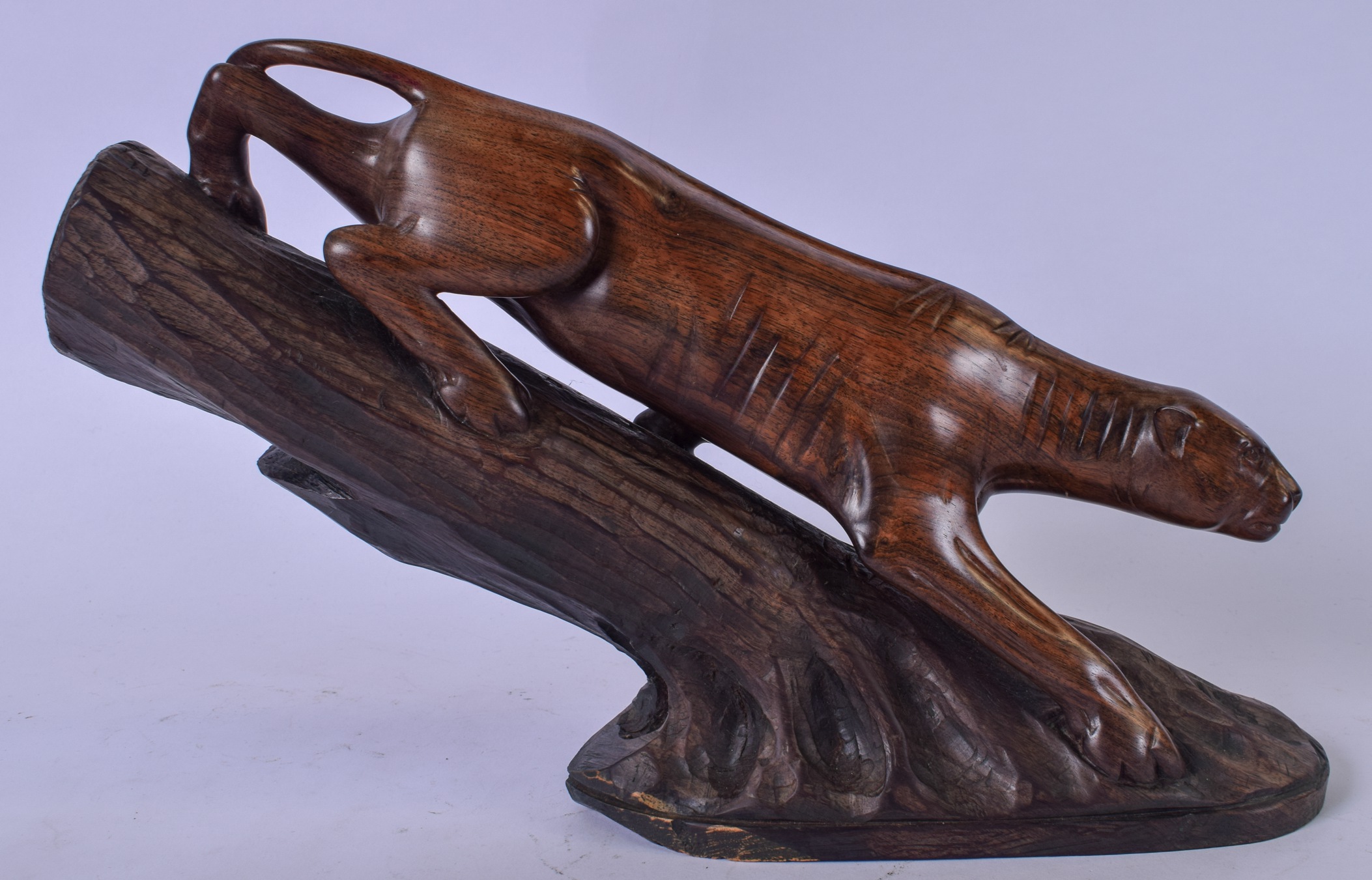 A LARGE CARVED WOODEN FIGURAL GROUP, in the form of a panther climbing down a tree trunk. 35 cm