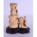 A 19TH CENTURY JAPANESE MEIJI PERIOD CARVED IVORY OKIMONO modelled daikoku beside a female. 9 cm x