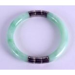 AN EARLY 20TH CENTURY CHINESE SILVER MOUNTED JADEITE BANGLE. 7.25 cm wide.