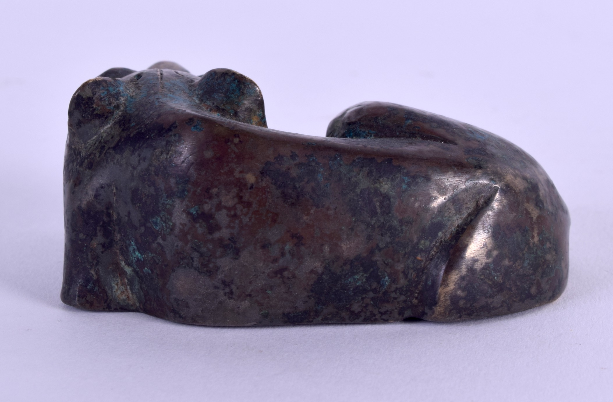 AN 18TH/19TH CENTURY CHINESE BRONZE FIGURE OF A RECUMBANT BEAST modelled upon its paws. 8 cm x 3. - Image 2 of 3