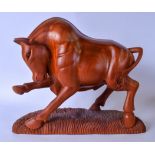 A LARGE CARVED WOODEN FIGURE OF A BULL, modelled with its front hoof raised on a naturalistic