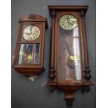 AN EARLY 20TH CENTURY WOODEN WALL CLOCK, together with a smaller example. Largest 103 cm.