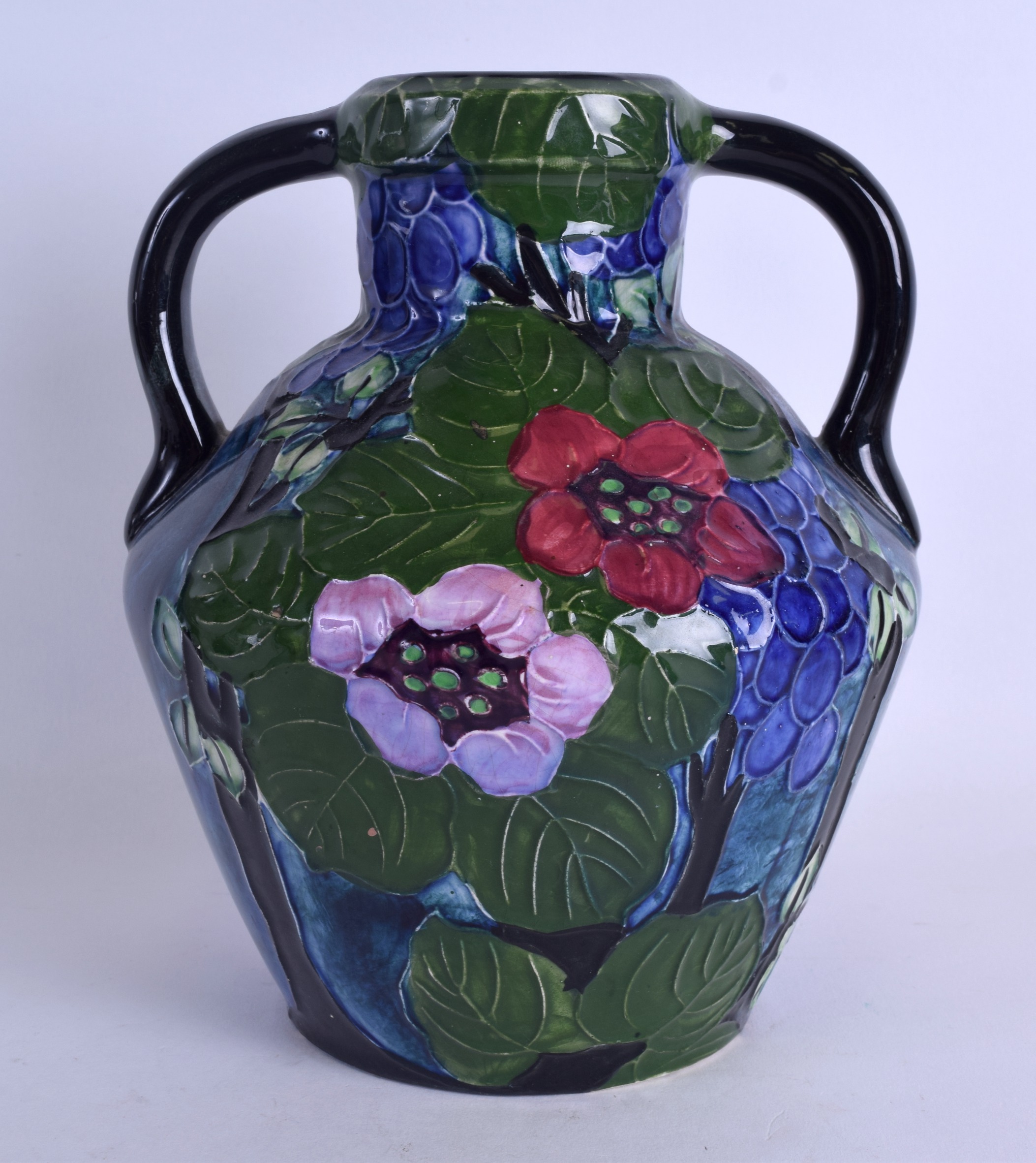 AN UNUSUAL TUBE LINED TWIN HANDLED TROGON WARE VASE decorated with a parrot amongst foliage. 22 cm x - Image 2 of 3