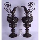 A LARGE PAIR OF 19TH CENTURY EUROPEAN BRONZE EWERS decorated with mythical figures upon an