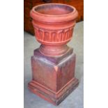 AN EARLY 20TH CENTURY TERRACOTTA URN, sat upon a square form stepped plinth. 60 cm x 30 cm.