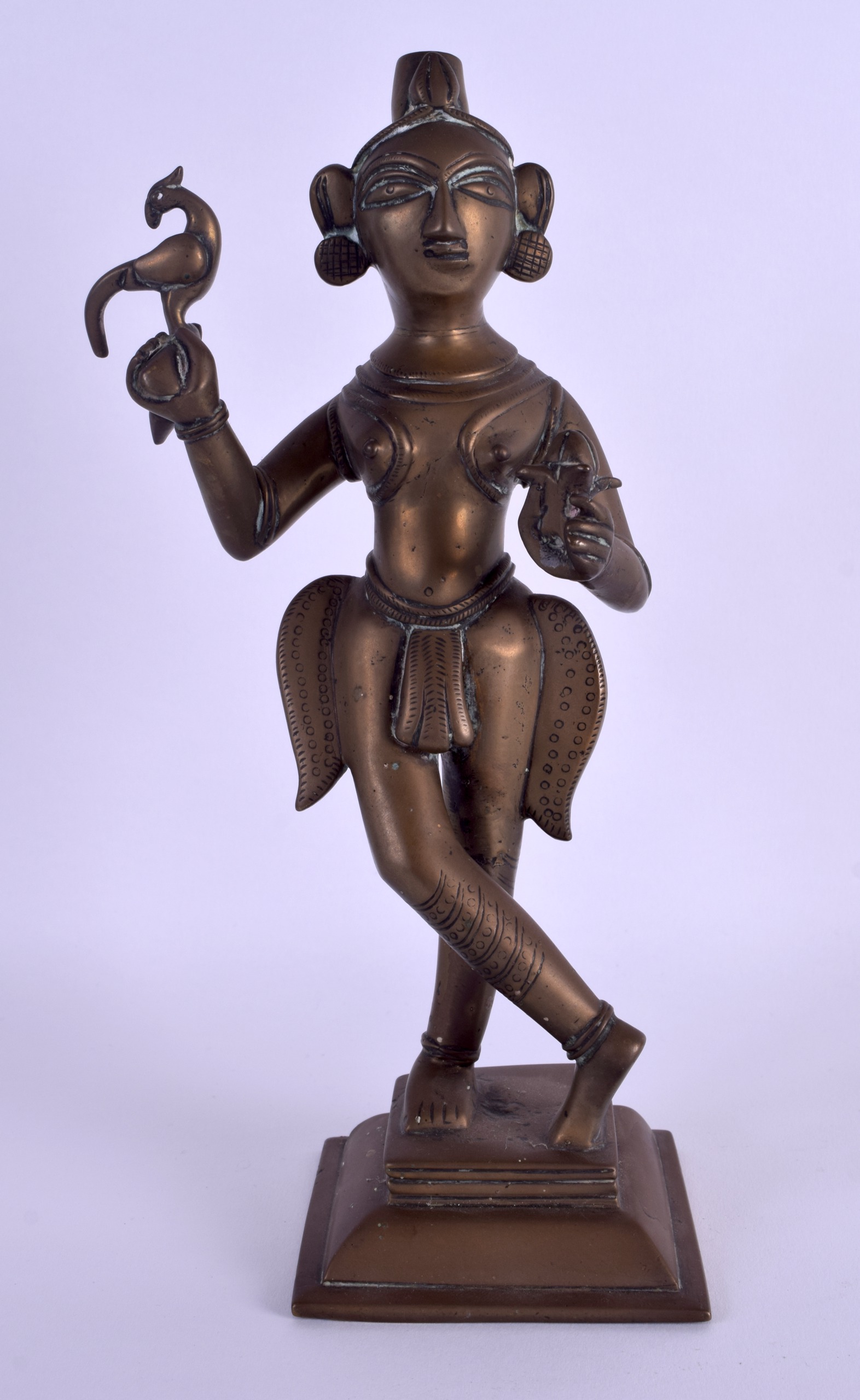 AN 18TH CENTURY INDIAN BRONZE FIGURE OF A STANDING DEITY modelled holding a Buddhistic ritual vessel