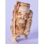 A CHINESE QING DYNASTY BONE STATUE OF SAGE, carved holding a staff. 5.5 cm high.