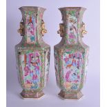 A PAIR OF 19TH CENTURY CHINESE FAMILLE ROSE TWIN HANDLED PORCELAIN VASES Qing, painted with