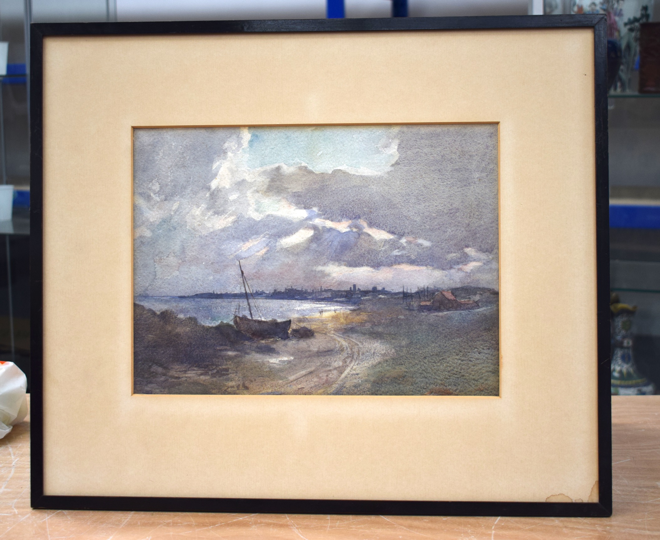 A FRAMED WATERCOLOUR by Henry Raeburn Dobson, depicting a coastal scene. 36 cm x 27 cm.