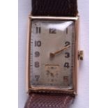 A 1930S GENTLEMANS 9CT GOLD WRISTWATCH with silvered dial and gold numerals. 2 cm x 3.25 cm.