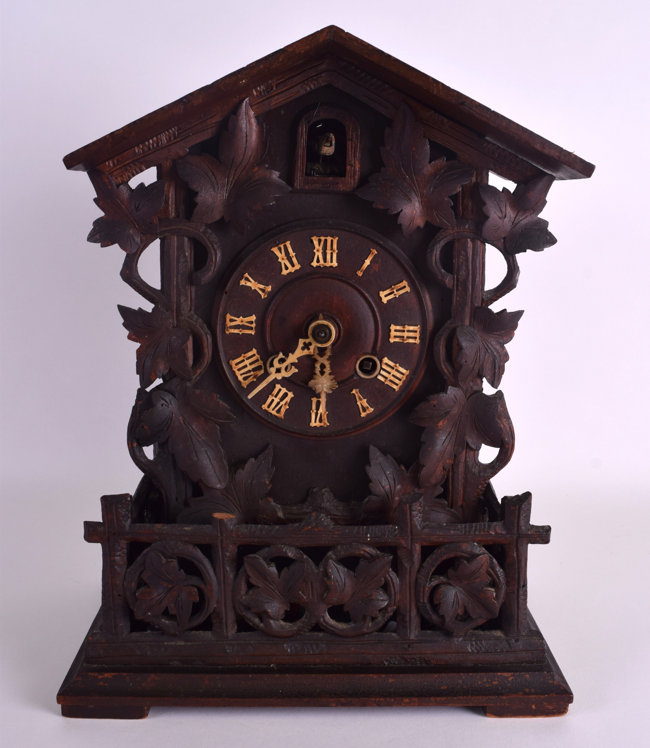 AN EARLY 20TH CENTURY GERMAN BAVARIAN BLACK FOREST CUCKOO CLOCK overlaid with vines and leaves. 39