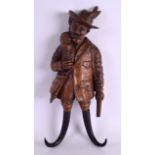 A 19TH CENTURY BAVARIAN CARVED BLACK FOREST HUNTER COAT HOOK modelled as a male holding his catch.
