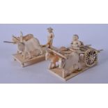 A PAIR OF EARLY 20TH CENTURY INDIAN IVORY FIGURES OF TRADESMEN, carved with oxen driven carts. 12 cm