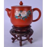 A CHINESE YIXING POTTERY TEA POT, decorated with peaches, together with hardwood stand. 12 cm wide.