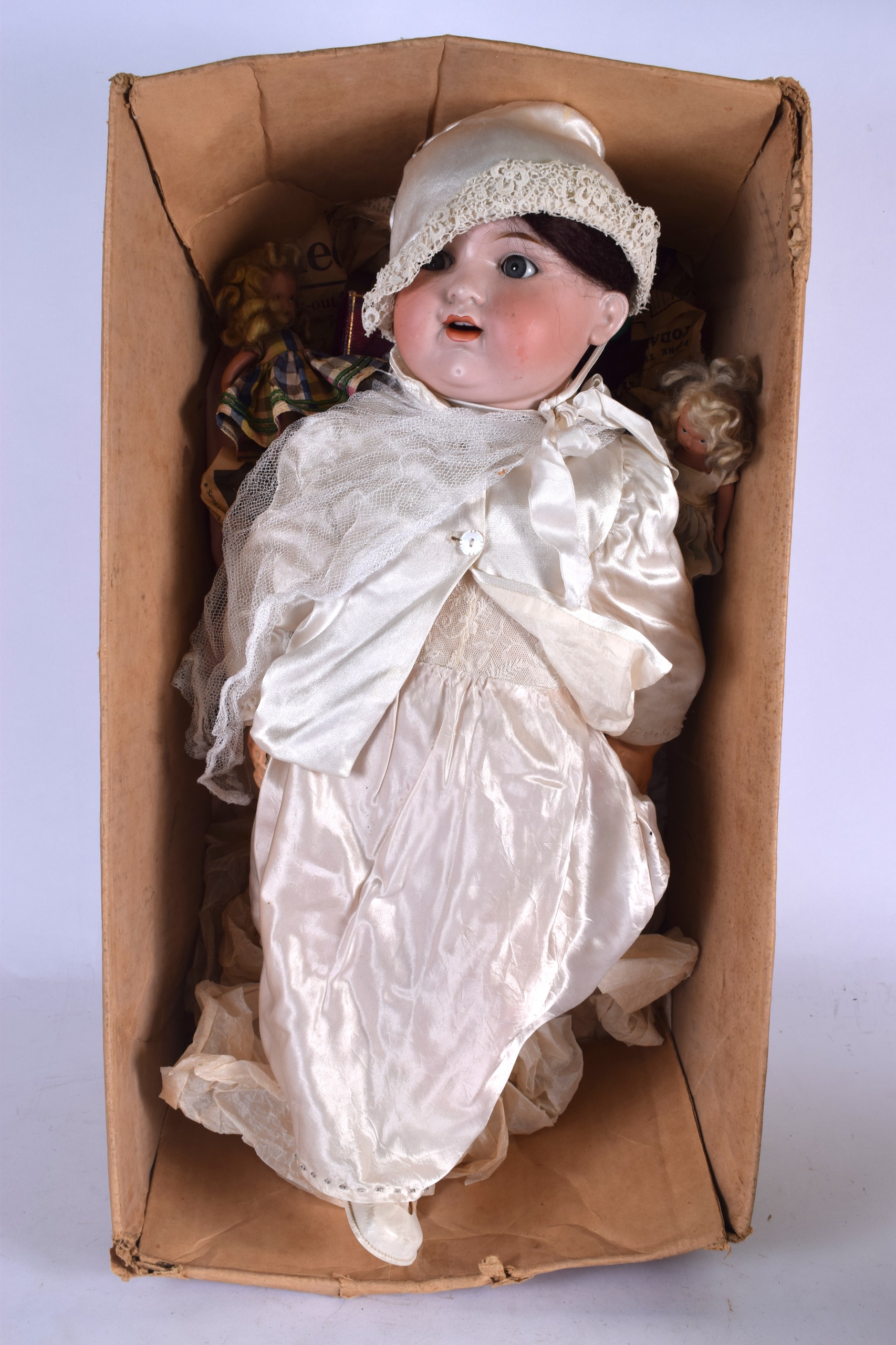 AN ANTIQUE PORCELAIN DOLL, together with two other smaller dolls. Largest 60 cm.