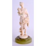 A 19TH CENTURY FRENCH CARVED IVORY FIGURE OF A STANDING FEMALE modelled holding a wreath and