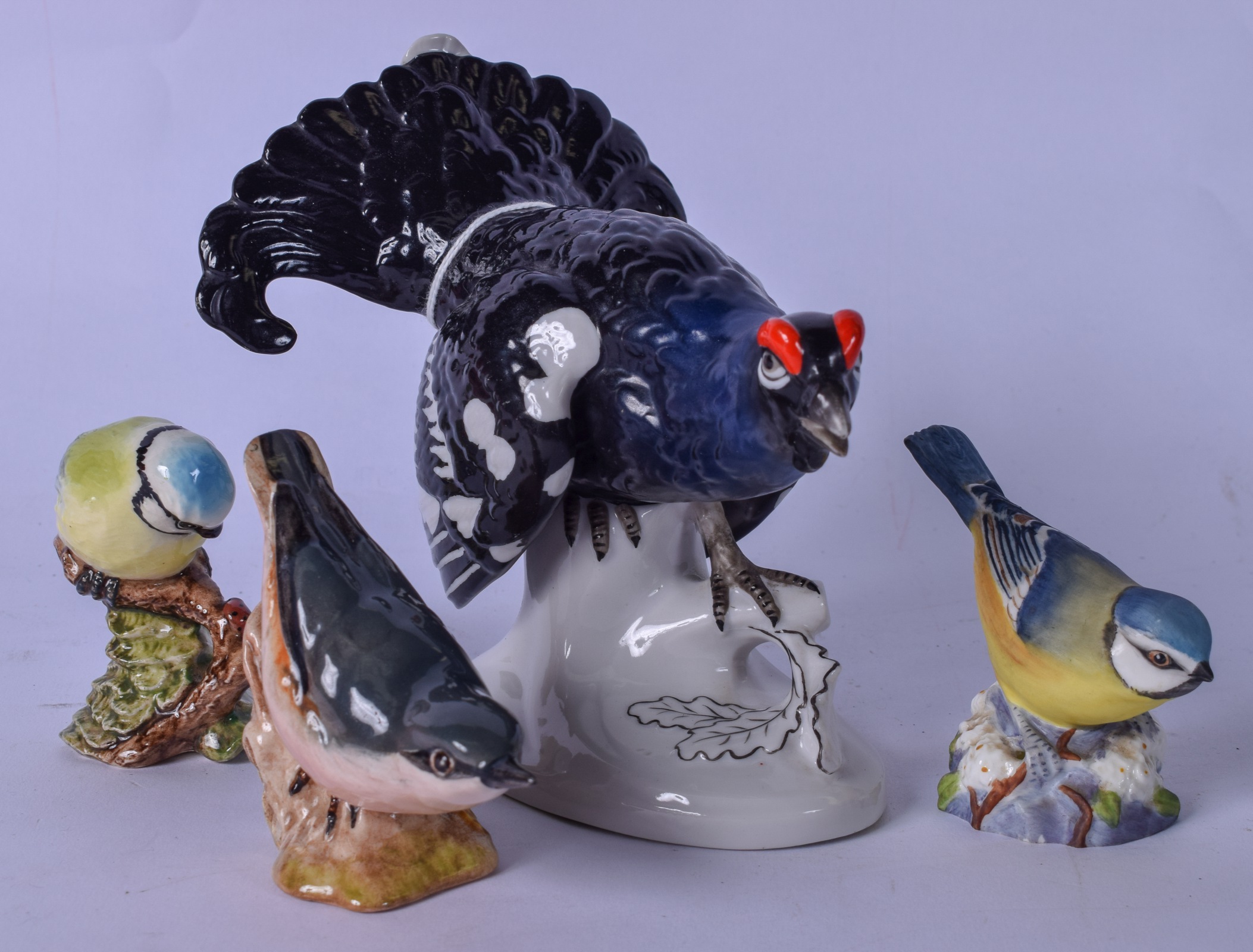 A WEISS KUHNERT & CO PORCELAIN FIGURINE OF A BLACK GROUSE, together with two Beswick porcelain birds