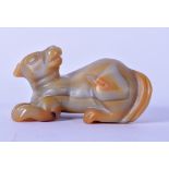 A CARVED HARDSTONE FIGURE ON A BEAST, modelled recumbent. 12.5 cm wide.