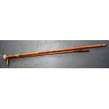 AN EARLY 20TH CENTURY IVORY HANDLED WALKING CANE, together with a bronze handled riding crop. (2)