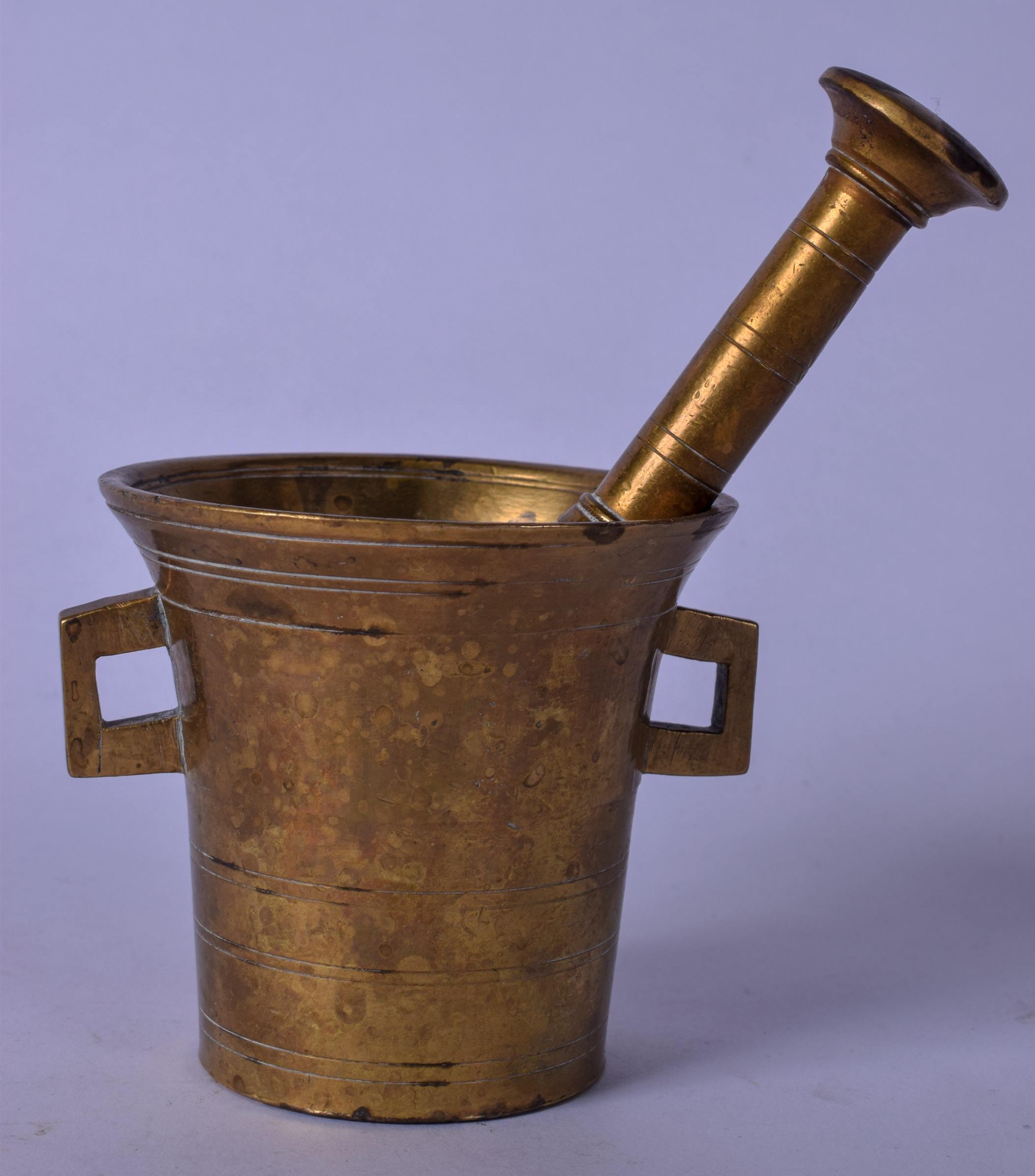 AN EARLY 20TH CENTURY PESTLE AND MORTAR, formed with twin handles. 9 cm and 16 cm.