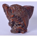 A CHINESE CARVED LIBATION CUP, carved in the form of a bird sat upon the back of a mythical beast.