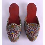 A PAIR OF EARLY 20TH CENTUYRY PERSIAN BEADWORK SLIPPERS decorated with floral motifs. 26 cm long.