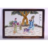 A 1960S CHINESE FAMILLE ROSE PORCELAIN PLAQUE painted with two males and female water carrier within