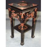 AN EARLY 20TH CENTURY CHINESE TWO TIERED LACQUERED STAND decorated with figures in various pursuits.