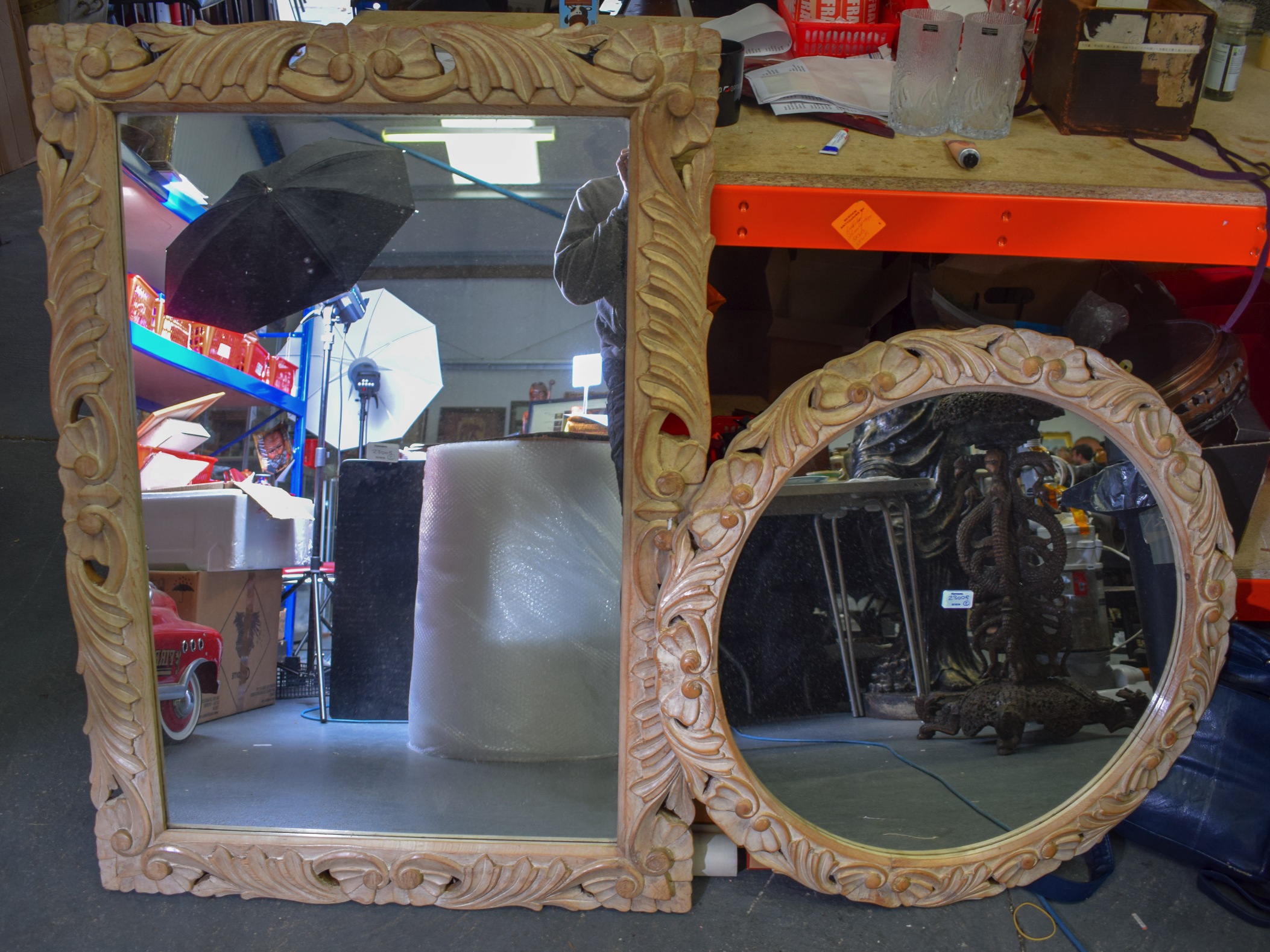 TWO 20TH CENTURY CARVED WOODEN MIRRORS, with scrolling floral inspired frames. Largest 111 cm x 78