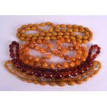 FOUR AMBER COLOURED NECKLACES in various forms and sizes. (4)