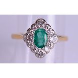 A STYLISH 18CT GOLD DIAMOND AND EMERALD FANCY RING the central emerald encased within fourteen 1/