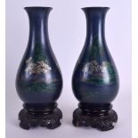 A PAIR OF EARLY 20TH CENTURY CHINESE LACQUERED VASES painted with landscapes upon fitted bases. 24
