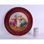 A LARGE EARLY 20TH CENTURY VIENNA PORCELAIN CHARGER painted with three classical females within a