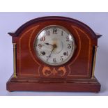 AN EDWARDIAN WOODEN MANTEL CLOCK, inlaid with satinwood depicting opposing fish. 33 cm wide.