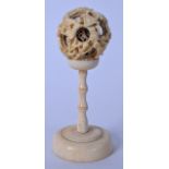 A 19TH CENTURY CHINESE CANTON IVORY PUZZLEBALL ON STAND, carved with figures in landscape scenery.