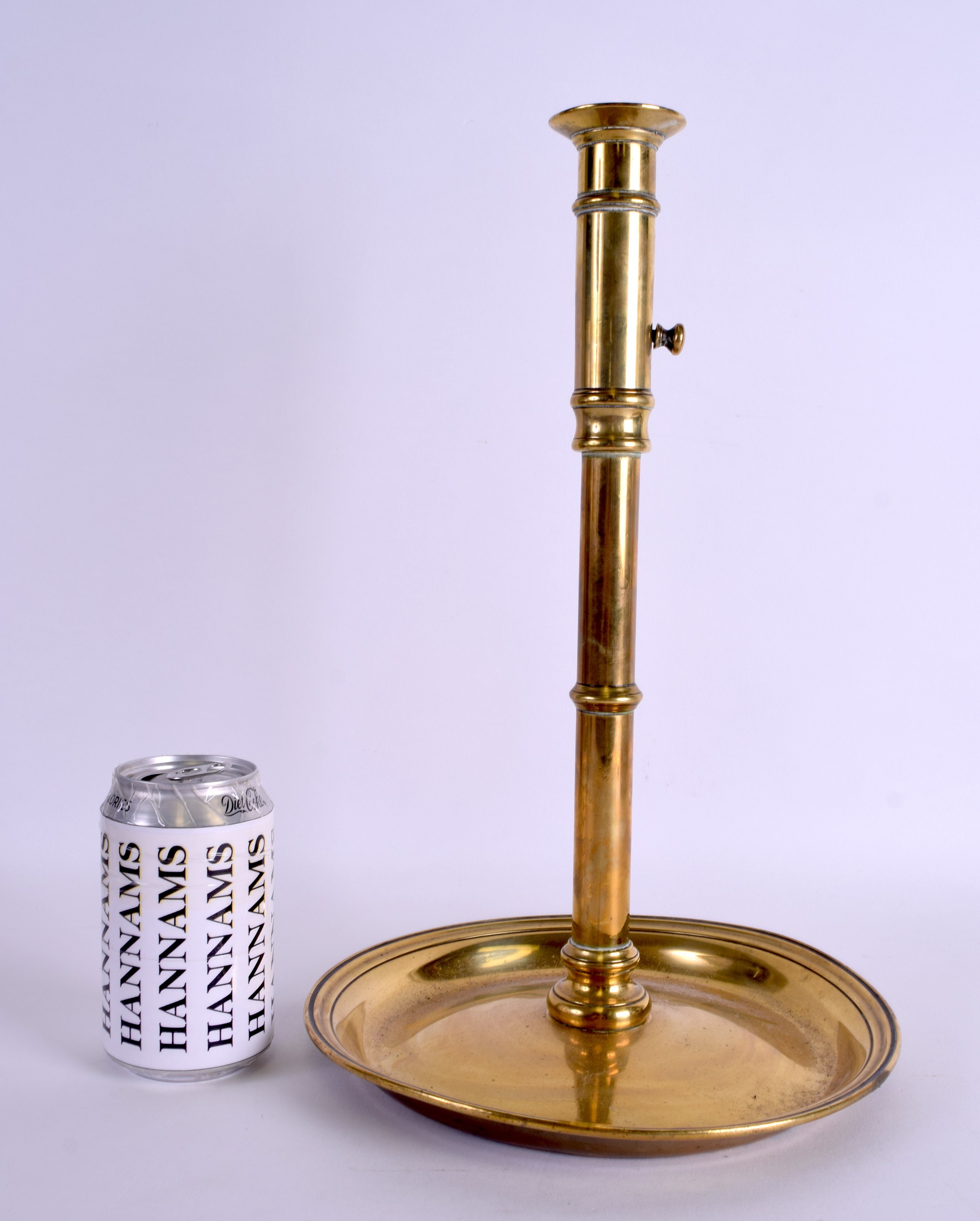 AN 18TH CENTURY CONTINENTAL ADJUSTABLE BRASS CANDLESTICK with large circular pan. 37 cm high.