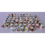 A COLLECTION OF SIXTY FOUR PORCELAIN THIMBLES, of various subject together with a carved wooden