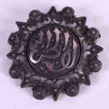 A 19TH CENTURY MIDDLE EASTERN ISLAMIC SILVER BROOCH decorated with foliage and motifs. 6.5 cm wide.