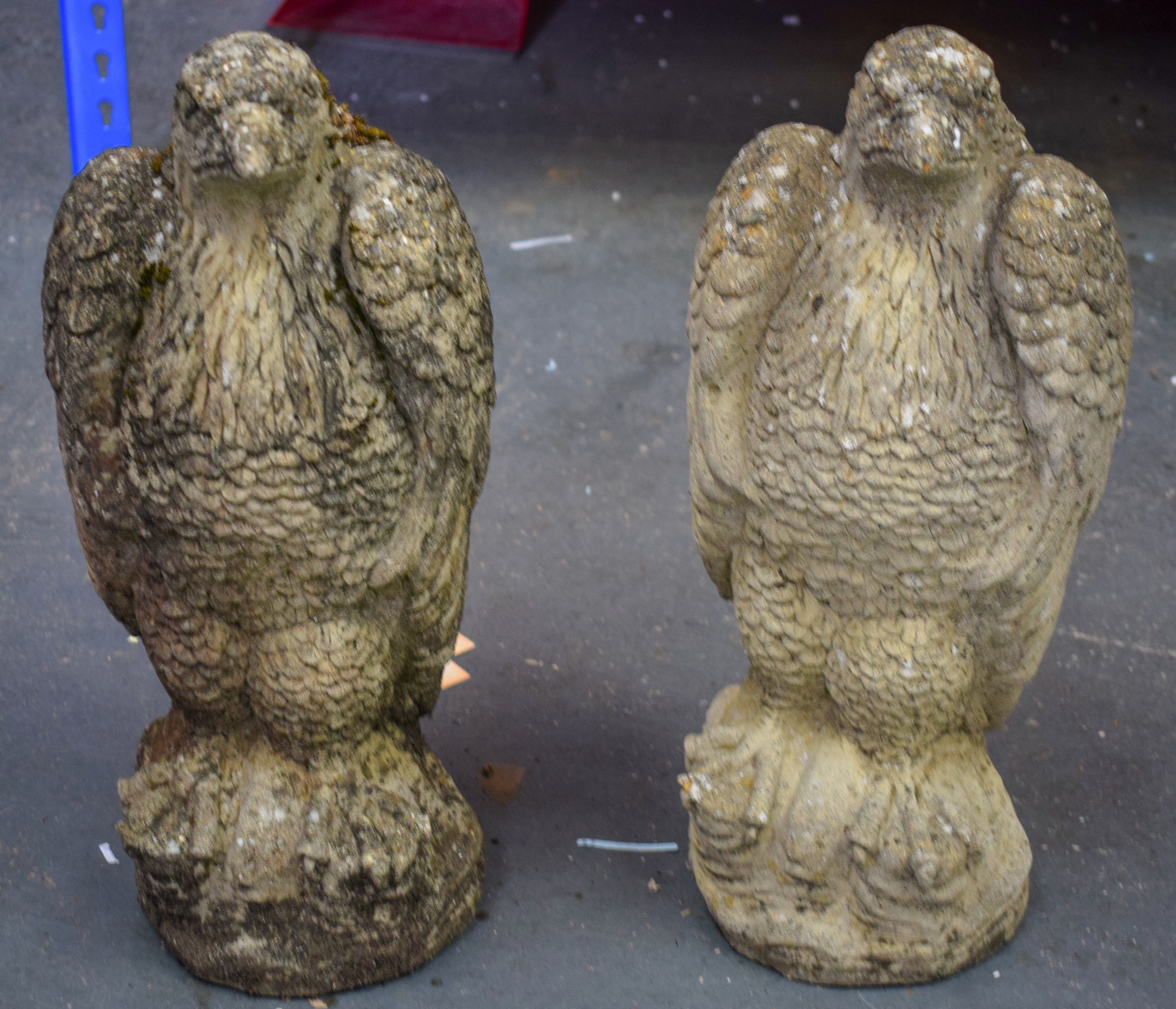 A LARGE PAIR OF CONCRETE EAGLES, formed seated upon a rock. 45 cm high.