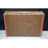 A LOUIS VUITTON TRAVELLING SUITCASE of traditional form and decoration. 70 cm x 46 cm x 18 cm.